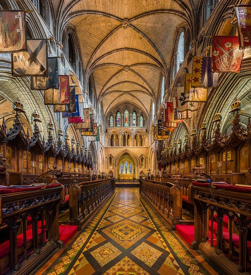 The interior of St. Patrick’s Cathedral features a central nave, side aisles, and a choir, shown here. Though most of the interior was reconstructed during the 19th century, the architects preserved the cathedral’s original Gothic appearance. The vaulted ceilings are supported by rows of towering columns, adorned with intricate carvings and ornate decorations. At the end of the nave is the high altar, topped by stained-glass windows. (Diliff/CC BY-SA 3.0)