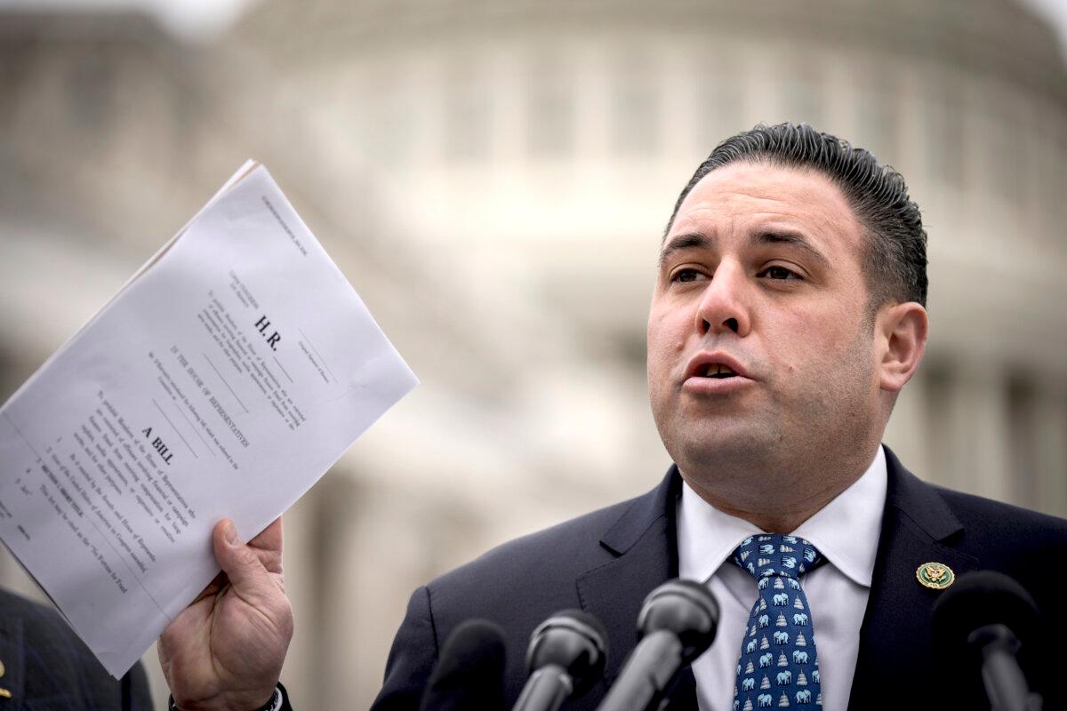 Rep. Anthony D'Esposito (R-N.Y.), while speaking at a news conference, holds up copies of legislation he plans to introduce, outside the Capitol in Washington on March 7, 2023. (Drew Angerer/Getty Images)