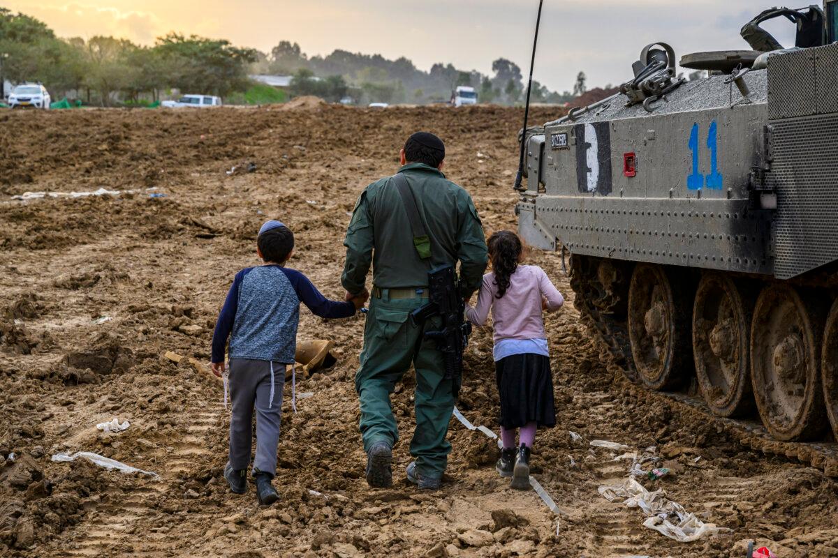 Children visit their father, who is currently on reservist duty, after returning from Gaza, in Southern Israel on Dec. 17, 2023. (Alexi J. Rosenfeld/Getty Images)