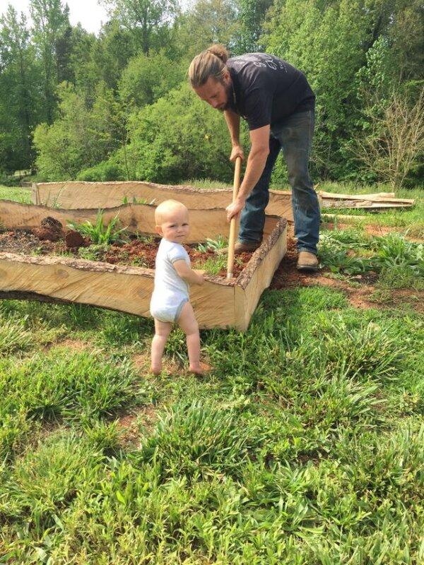 Ben Hollar tends the garden at his family's North Carolina property with the "help" of his young daughter.