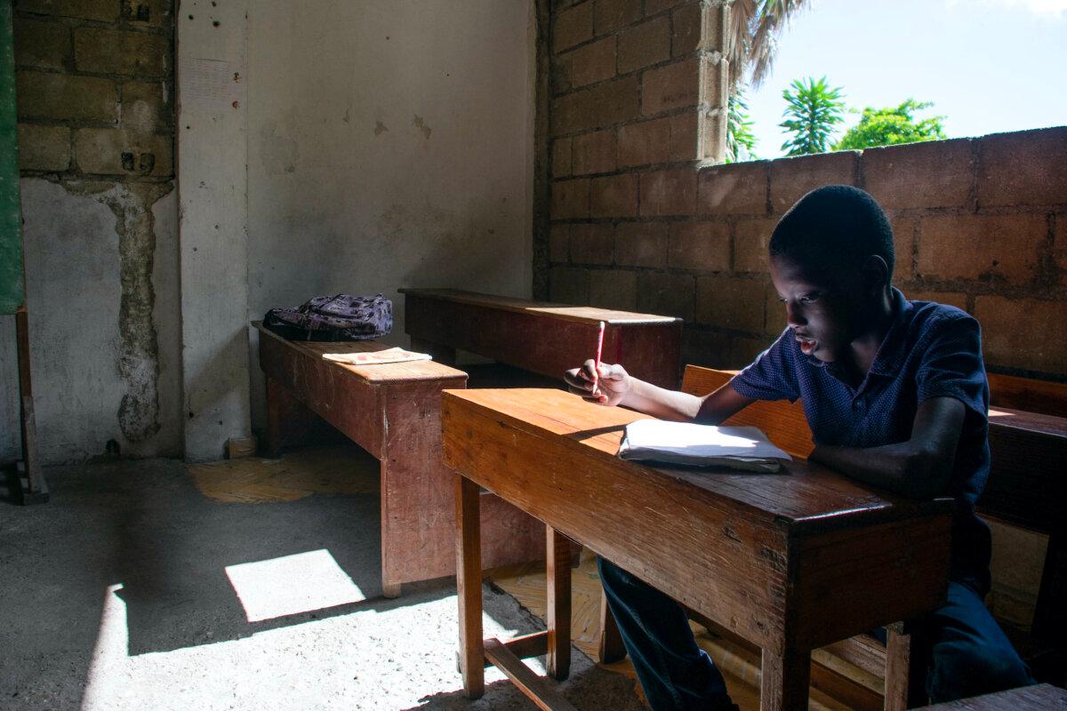 A student works in a classroom on the first day back at school in Port-au-Prince, Haiti, on April 29, 2024. Schools were closed after a deadly gang assault on the capital's main prison that allowed thousands of inmates to escape overnight on March 3, 2024. (Clarens Siffroy/AFP via Getty Images)