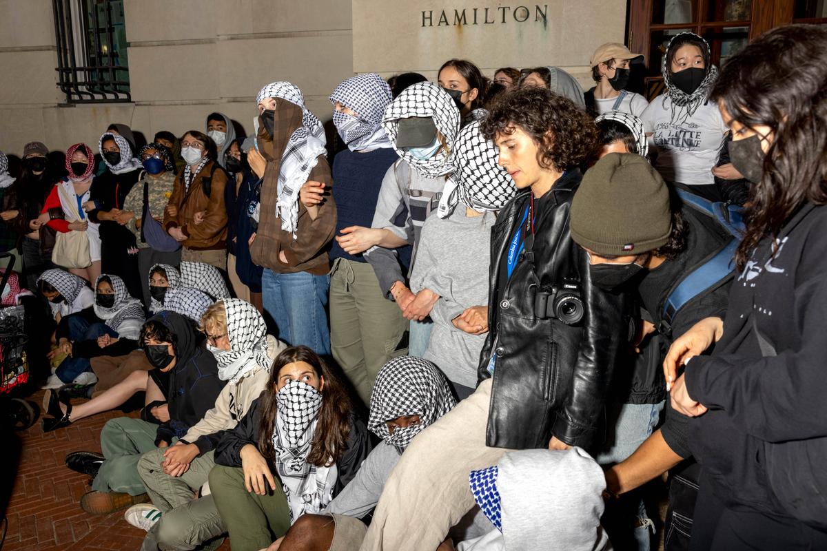 Students/protestors lock arms to guard potential authorities against reaching fellow protestors who barricaded themselves inside Hamilton Hall, an academic building which has been occupied in past student movements, in New York on April 30, 2024. (Alex Kent/Getty Images)