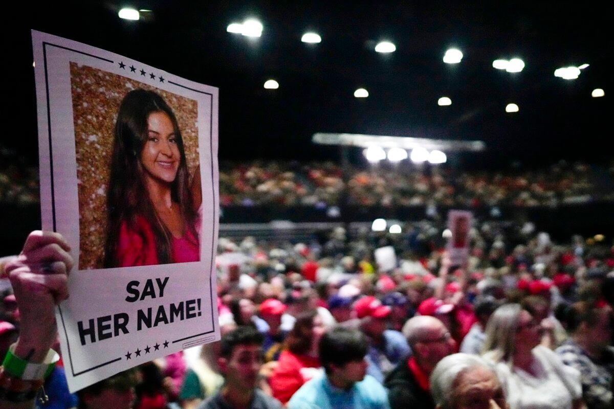 A supporter holds a sign with a photo of Laken Riley before Republican presidential candidate former President Donald Trump speaks at a campaign rally in Rome Ga., on March 9, 2024. (Mike Stewart/AP Photo)