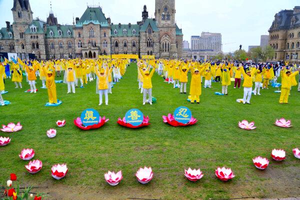 Falun Gong adherents demonstrate a meditative exercise on Parliament Hill during Falun Dafa Day celebrations on May 8, 2024. (Jonathan Ren/The Epoch Times)