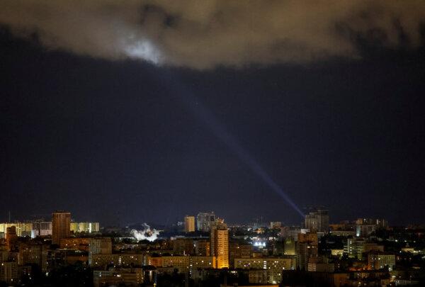 Ukrainian servicemen use a searchlight as they search for drones in the sky over the city during a Russian drone and missile strike in Kyiv, Ukraine, on May 8, 2024. (Gleb Garanich/Reuters)