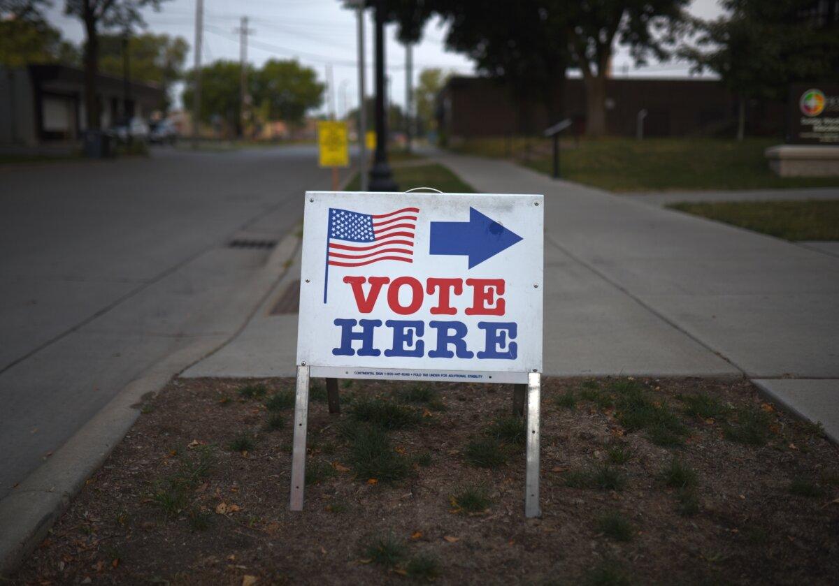 A sign reading "Vote Here" points toward a polling place for the 2018 Minnesota primary election at Holy Trinity Lutheran Church, in Minneapolis, Minn., on Aug. 14, 2018. (Stephen Maturen/Getty Images)