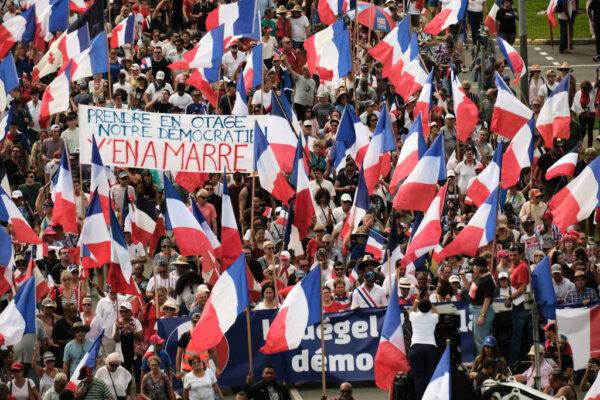 Demonstrators from several loyalist parties wave French national flags and hold a banner reading "Prendre en otage notre democratien y'en a marre" (Take our democracy away from you). (Theo Rouby/AFP via Getty Images)