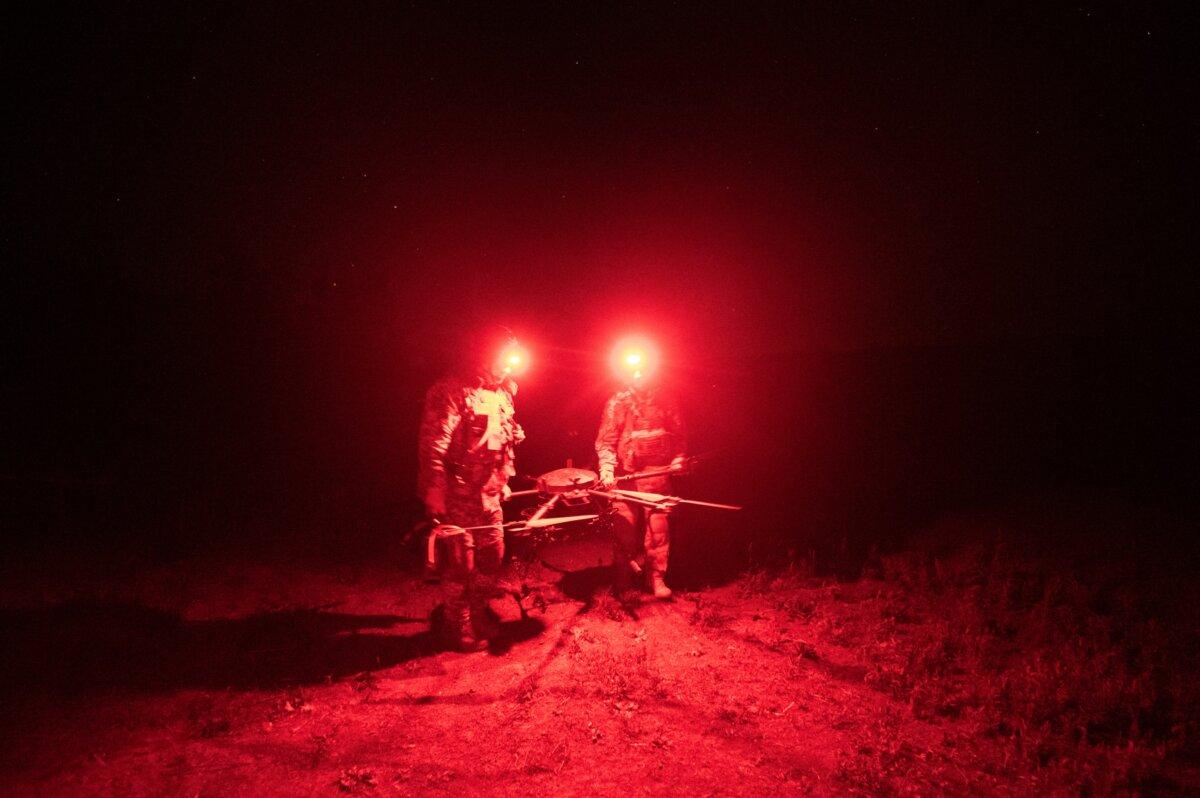 Amid the Russian invasion of Ukraine, servicemen of the "Achilles" Battalion from the 92nd assault brigade of the Ukrainian Army carry a Vampire hexacopter drone after a mission flight over a frontline near Chasiv Yar, Donetsk region, on May 1, 2024. (Genya Savilov/AFP via Getty Images)