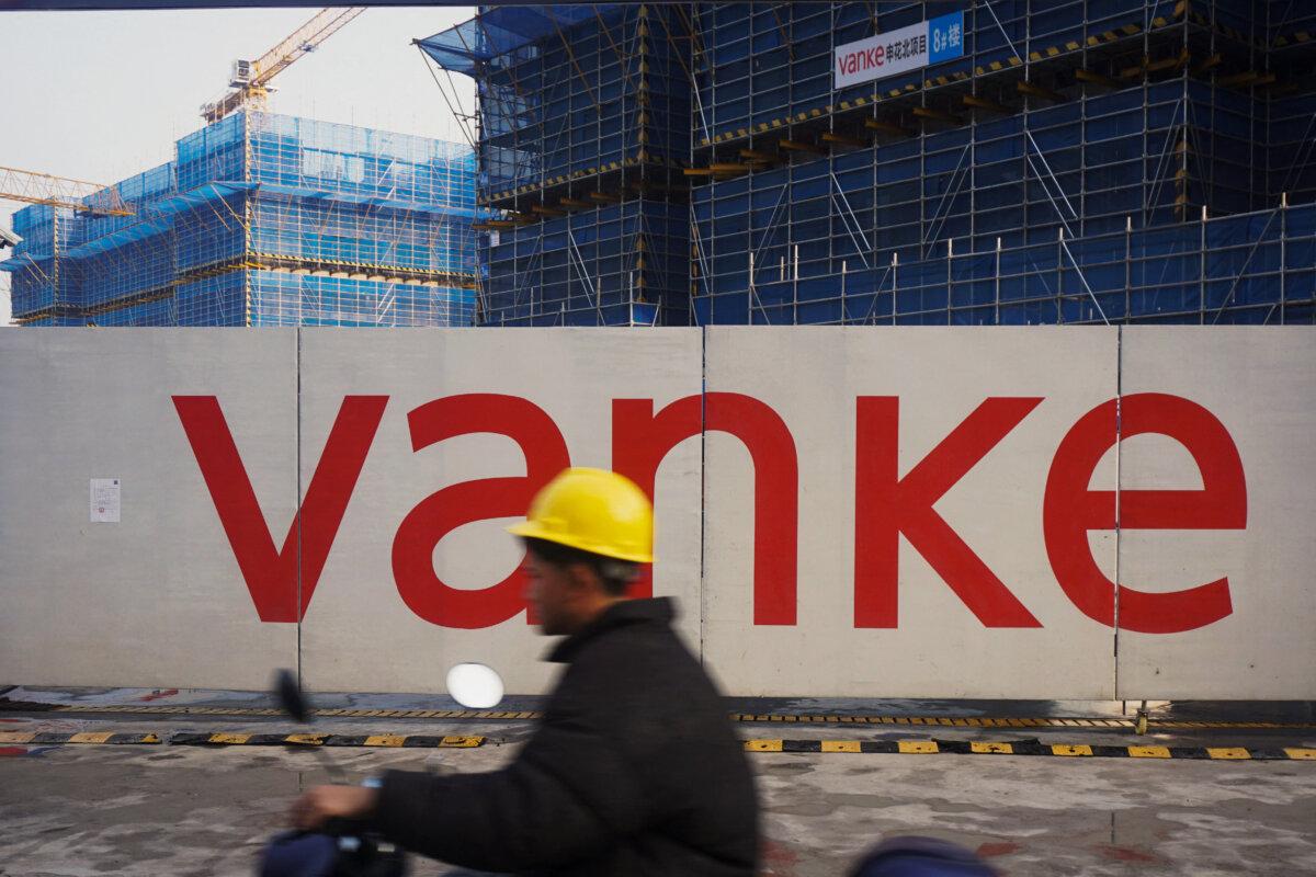 A worker drives past residential buildings under construction by Chinese real estate developer Vanke in Hangzhou, in eastern China's Zhejiang province on March 31, 2024. (STR/AFP via Getty Images)