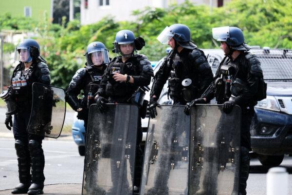 French Gendarmerie stand with their shields at the entrance of the Vallee-du-Tir district, in Noumea on May 14, 2024. (Theo Rouby/AFP via Getty Images)
