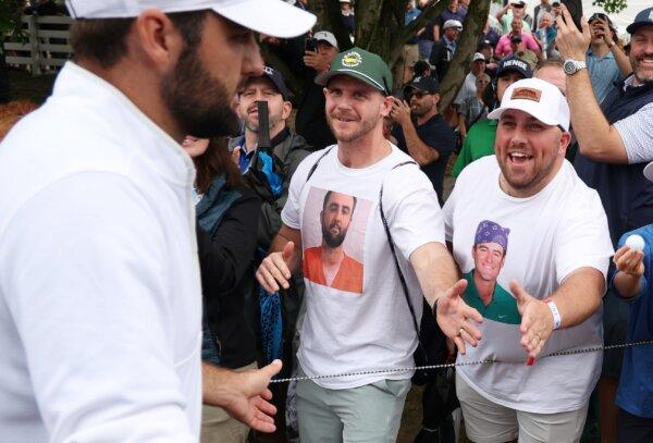 Scottie Scheffler of the United States shakes hands with fans wearing Scottie Scheffler t-shirts as he walks off the ninth green during the second round of the 2024 PGA Championship in Louisville, Kentucky, on May 17, 2024. (Patrick Smith/Getty Images)
