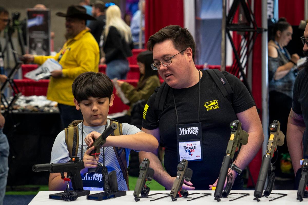 People try out firearms at the 2024 National Rifle Association exhibit at the Kay Bailey Hutchison Convention Center in Dallas on May 18, 2024. (Madalina Vasiliu/The Epoch Times)