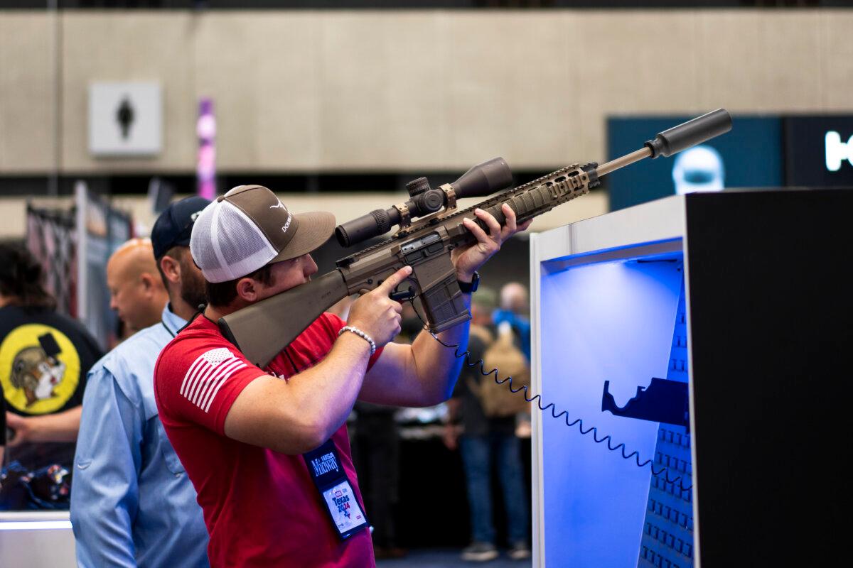 People try out firearms at the National Rifle Association exhibits at the Kay Bailey Hutchison Convention Center in Dallas on May 18, 2024. (Madalina Vasiliu/The Epoch Times)