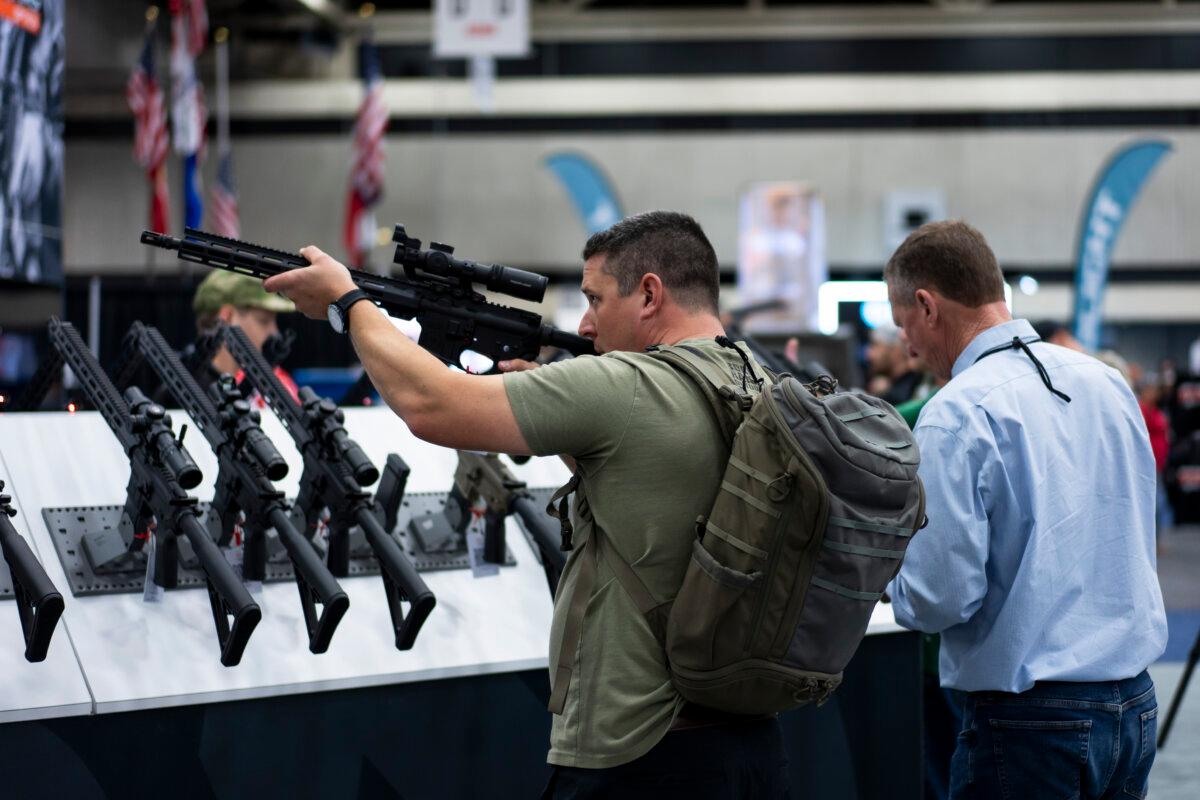 People try out firearms at the National Rifle Association exhibits at the Kay Bailey Hutchison Convention Center in Dallas on May 18, 2024. (Madalina Vasiliu/The Epoch Times)