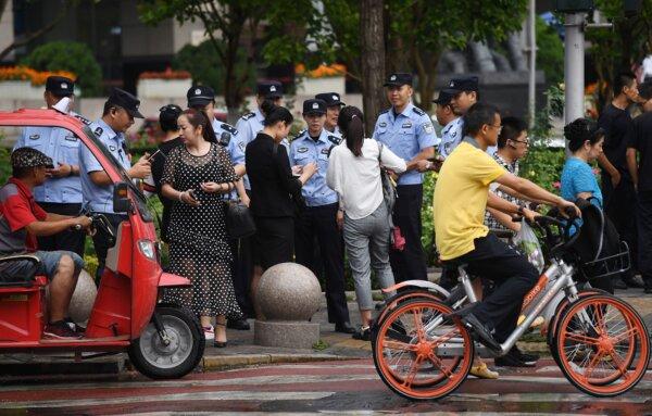 Police will check the passive of the passerby when searching for a petitioner near the Chinese Bank Regulatory Commission on August 6, 2018 (Greg Baker/AFP via Getty Images).