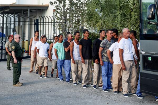 Illegal aliens from Cuba line up to board a bus to be driven to a U.S. Customs and Border Protection station as they are processed in Marathon, Fla., on Jan. 5, 2023. (Joe Raedle/Getty Images)
