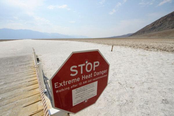 Signage warns of extreme heat danger at the salt flats of Badwater Basin inside Death Valley National Park in Inyo County, Calif., on June 17, 2021. (Patrick T. Fallon/AFP via Getty Images/TNS)on June 17, 2021,