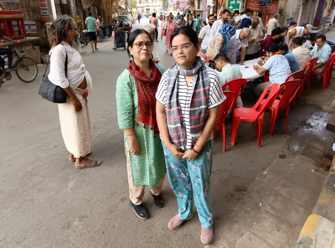 Anushya Sinha, 26, a first-time voter, stands with her mother at a polling booth in Assi Ghat, India, on June 1, 2024. (Venus Upadhayaya/The Epoch Times)