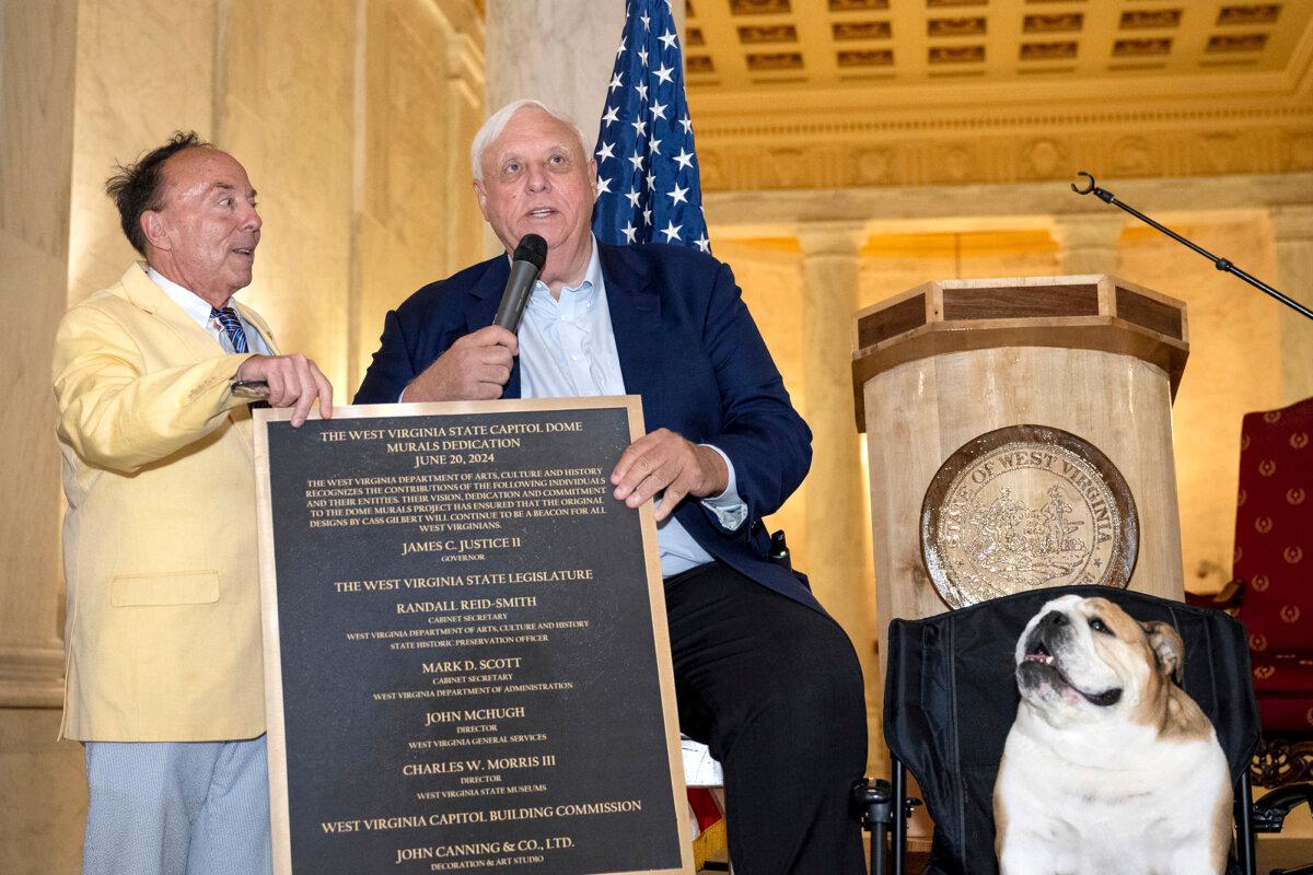 Randall Reid-Smith (L), West Virginia secretary of the Department of Arts, Culture and History, as he hands Gov. Jim Justice (C) a commemorative plaque about four new murals installed at the West Virginia Capitol in Charleston, W.Va., on June 20, 2024. (Perry Bennett/West Virginia Legislature via AP)