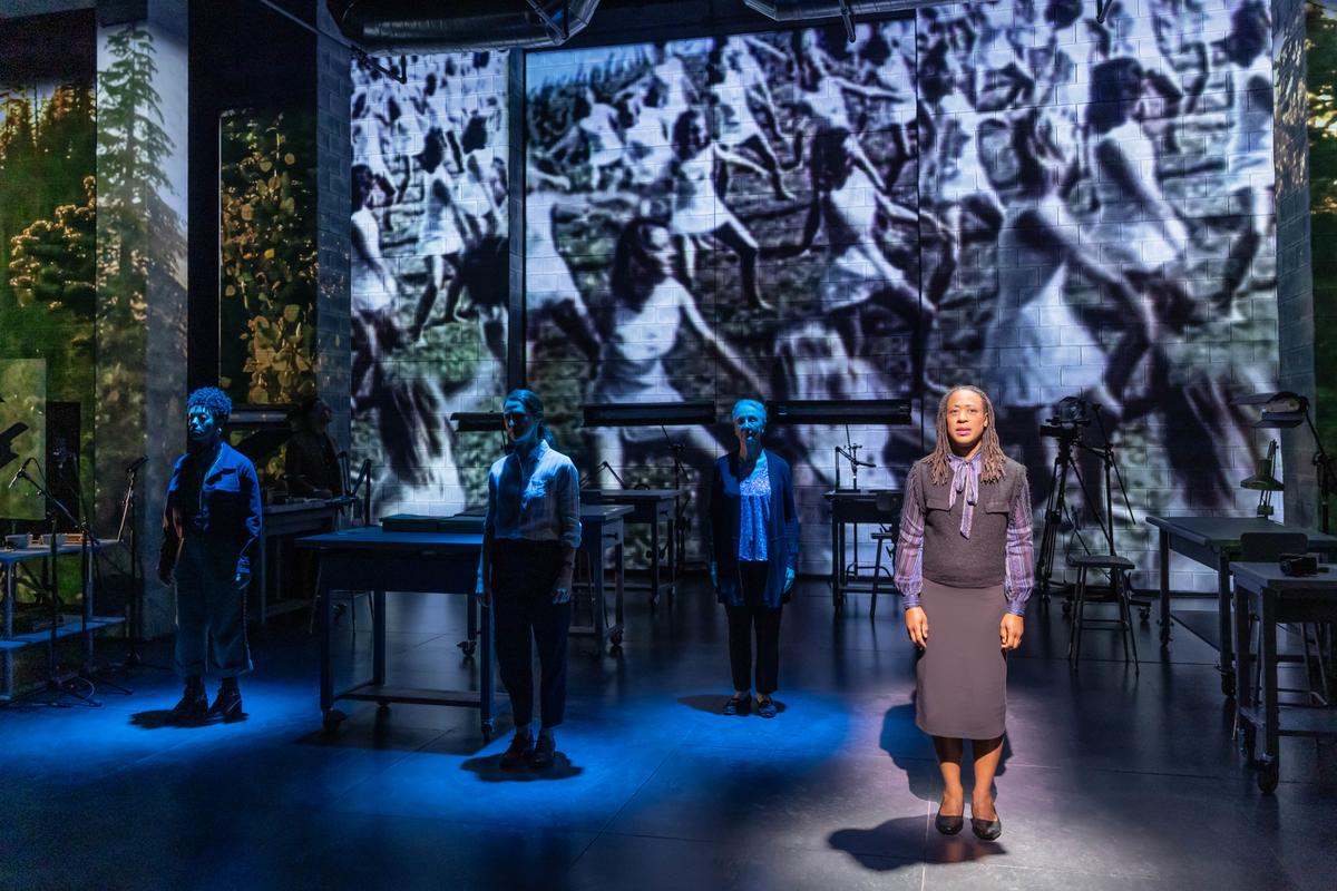 The cast of "Here There Are Blueberries" against a backdrop of historical photos from World War II. (Matthew Murphy)