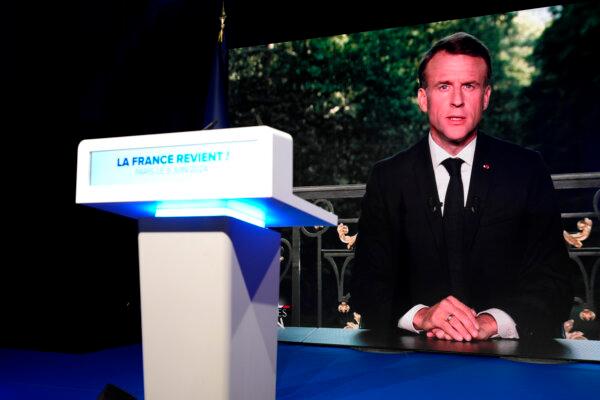 French President Emmanuel Macron appears on a television screen at the National Rally party election night headquarters in Paris on June 9, 2024. (Lewis Joly/AP Photo)