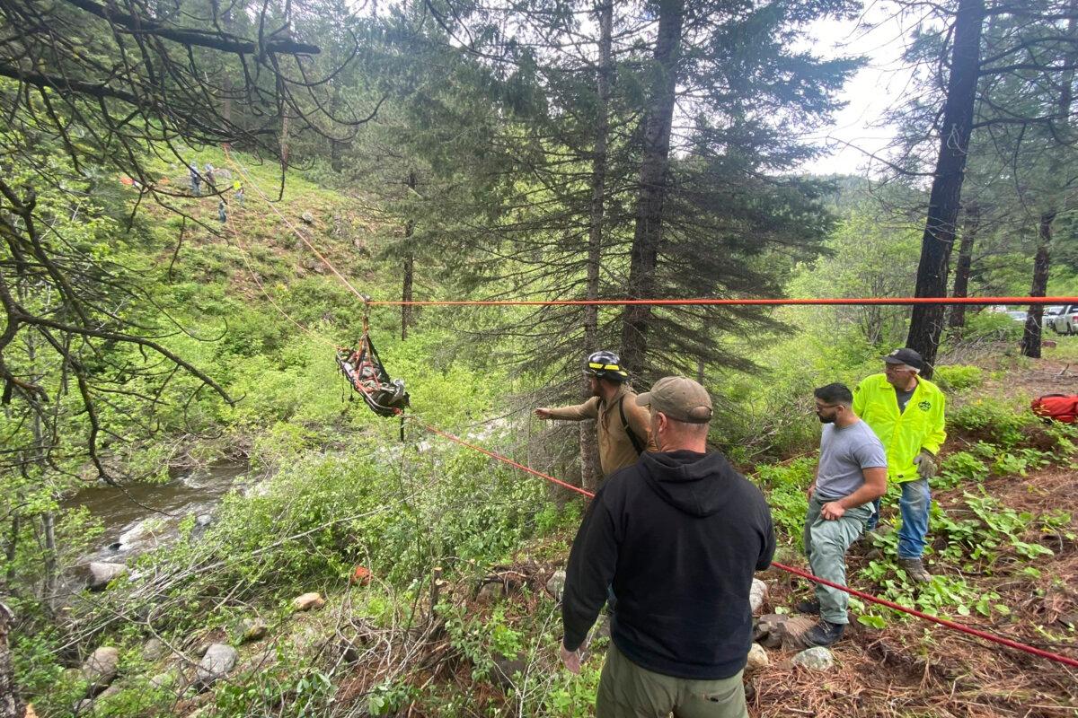 Responders aid in rescue efforts after a vehicle went into an embankment on U.S. Forest Service Road 39 in Oregon on June 3, 2024. (Baker County Sheriff's Office via AP)