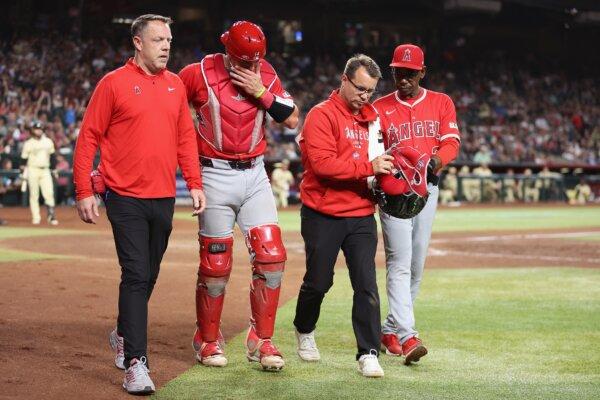 Catcher Logan O'Hoppe (14) of the Los Angeles Angels is helped off the field after an injury from a foul ball during the sixth inning of the MLB game against the Arizona Diamondbacks in Phoenix on June 11, 2024. (Christian Petersen/Getty Images)