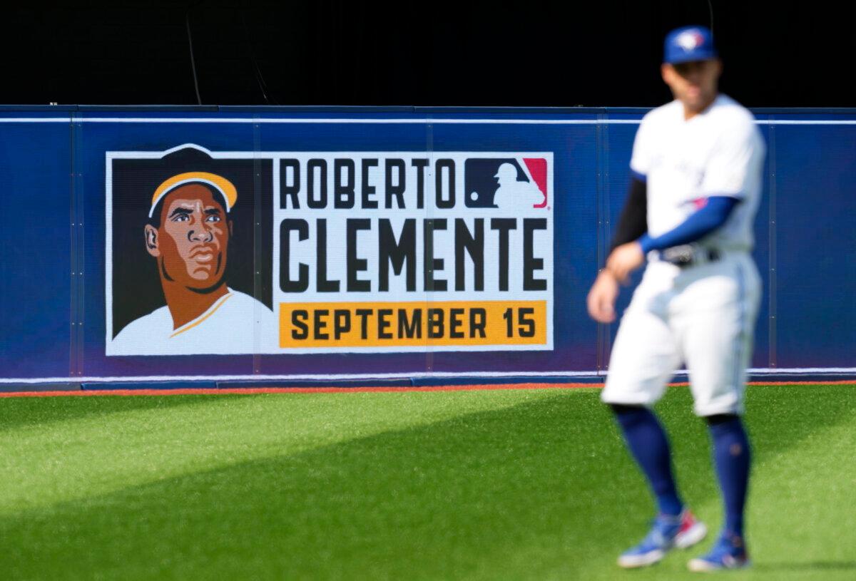 A Roberto Clemente Day sign is seen behind George Springer #4 of the Toronto Blue Jays before the Blue Jays play the Tampa Bay Rays in their MLB game at the Rogers Centre in Toronto, Ontario, Canada on Sept. 15, 2022. (Mark Blinch/Getty Images)