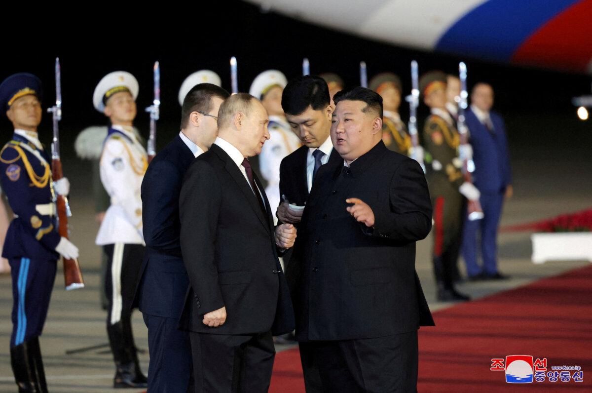 Russian President Vladimir Putin (L) is welcomed by North Korean leader Kim Jong Un (R) upon his arrival at an airport in Pyongyang, North Korea, on June 19, 2024. (KCNA via Reuters)