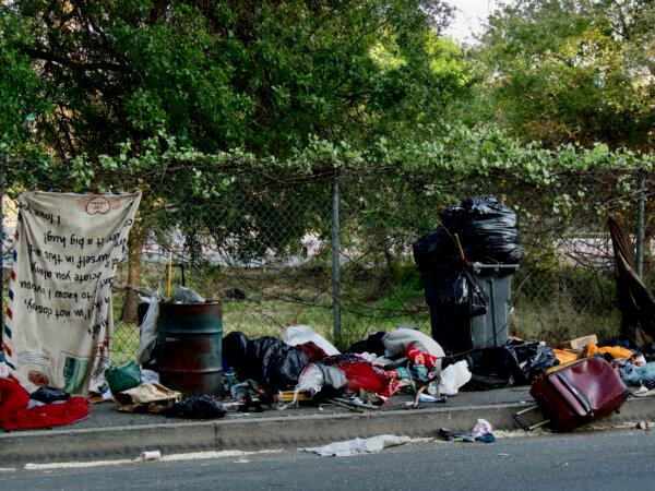 Trash on the street after a homeless camp was swept in Sacramento, as seen on April 22, 2024. (Travis Gillmore/The Epoch Times)