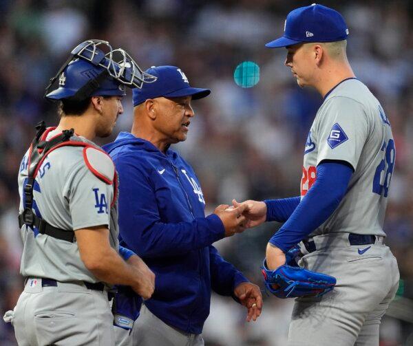 Los Angeles Dodgers manager Dave Roberts (C) takes the ball from starting pitcher Bobby Miller (R) as he is pulled from the mound while catcher Austin Barnes looks on in the seventh inning of a baseball game against the Colorado Rockies in Denver on June 19, 2024. (David Zalubowski/AP Photo)