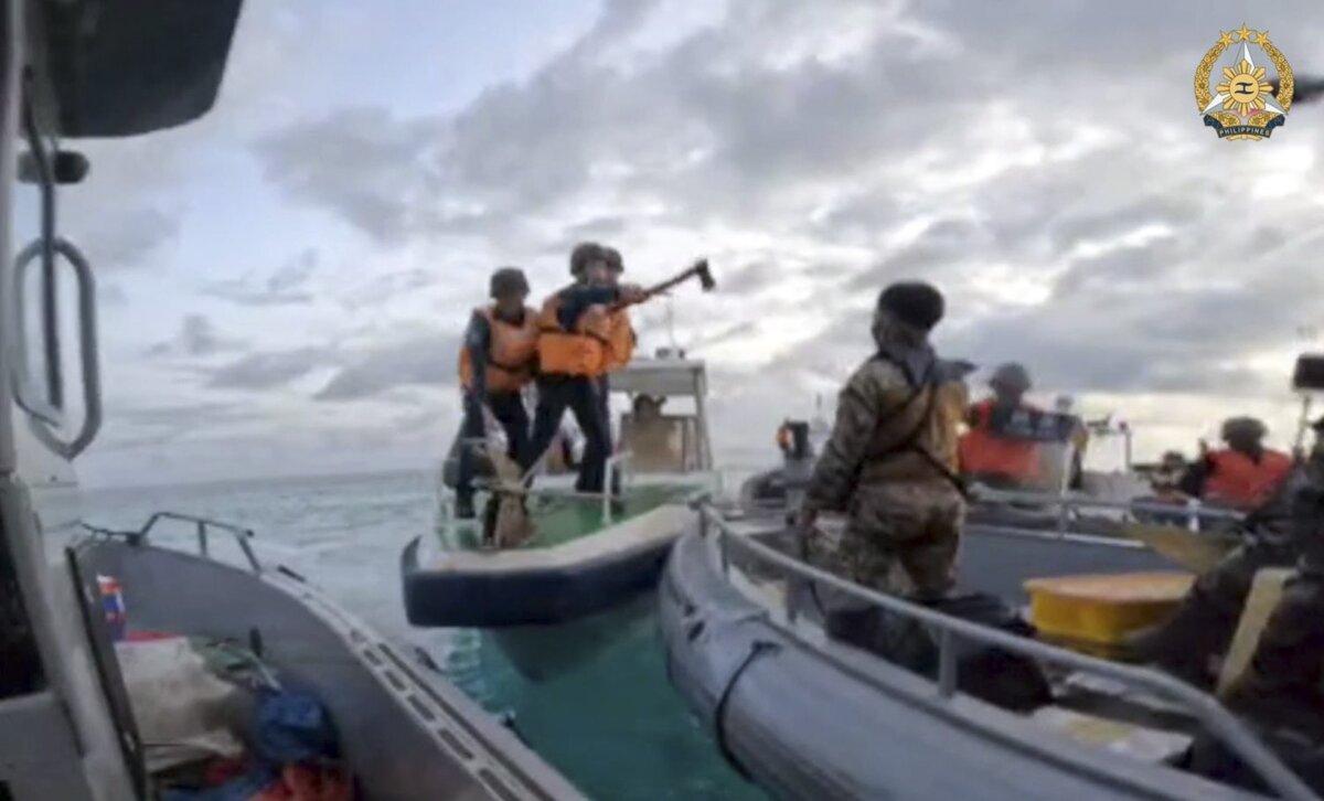 In this handout photo provided by the armed forces of the Philippines, Chinese coast guard members hold knives and machetes as they approach Filipino troops on a resupply mission in the Second Thomas Shoal in the South China Sea on June 17, 2024. (Philippine armed forces via AP)
