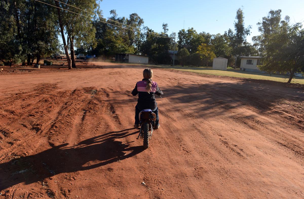 A young Queenslander rides her motorcycle at the family's cattle and sheep property near St George in south-western Queensland, Australia on Aug. 12, 2014. (AAP Image/Dan Peled)