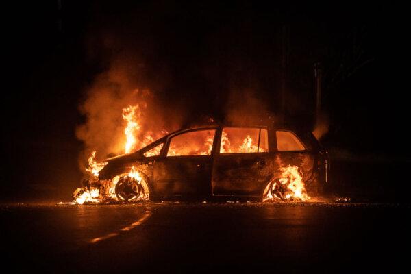 A car on fire on Riviere Salee's main road in Noumea, in the French Pacific territory of New Caledonia, on June 24, 2024. (Delphine Mayeur/AFP via Getty Images)
