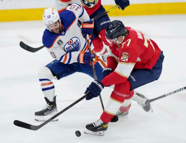 Edmonton Oilers forward Derek Ryan (L) and Florida Panthers defenseman Niko Mikkola battle for the puck during the first period of Game 7 of the Stanley Cup Final in Sunrise, Fla., on June 24, 2024. (Nathan Denette/The Canadian Press via AP)