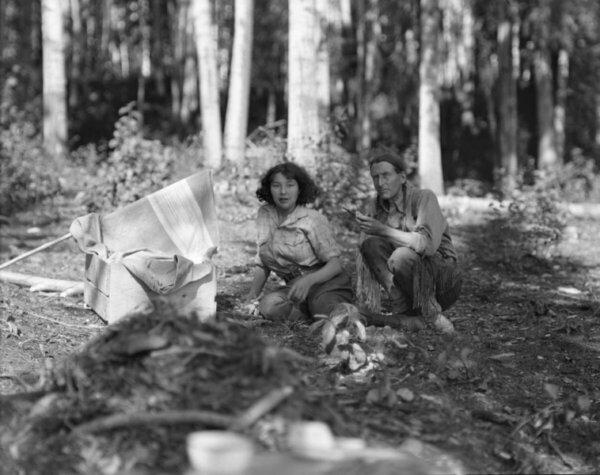 Grey Owl and his wife, Anahareo, sit together near Lake Ajawaan in Saskatchewan, circa 1933–34. (W. J. Oliver)