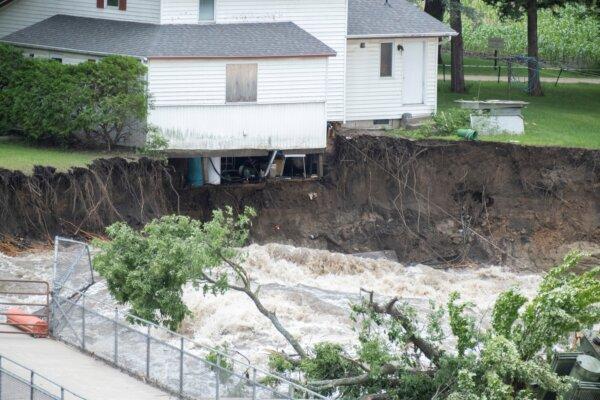 The innards of a house near the Rapidan Dam in Rapidan, Minn., are visible as waters from the Blue Earth River rush by, on June 24, 2024. (Casey Ek/The Free Press via AP)