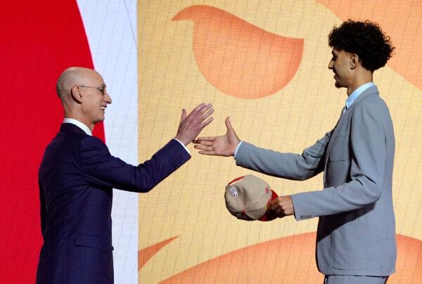 Adam Silver, Commissioner of the National Basketball Association (NBA), shakes hands with French basketball player Zaccharie Risacher (R) during Round One of the 78th edition of the NBA's annual draft at Barclays Center in Brooklyn, on June 26, 2024. (Timothy A. Clary/AFP via Getty Images)