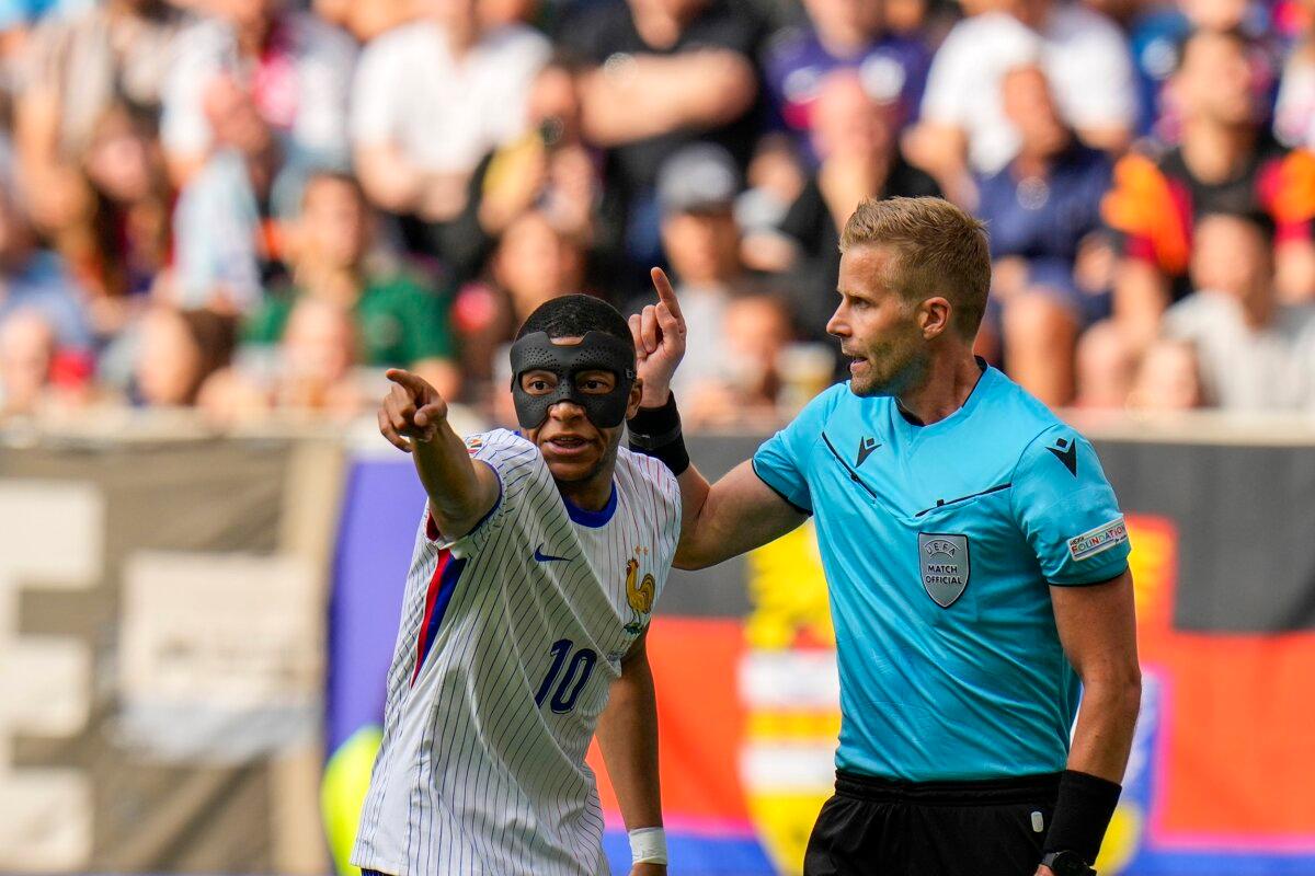 France's Kylian Mbappe (L) talks to Swedish referee Glenn Nyberg during a round of sixteen match between France and Belgium at the Euro 2024 soccer tournament in Dusseldorf, Germany, on July 1, 2024. (Hassan Ammar/AP Photo)
