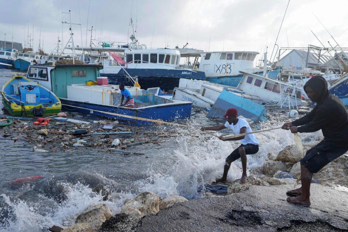 Fishermen pull a boat damaged by Hurricane Beryl back to the dock at the Bridgetown Fisheries in Barbados, on July 1, 2024. (Ricardo Mazalan/AP Photo)