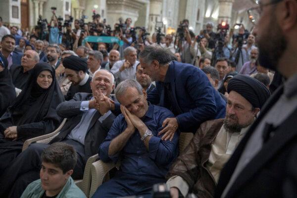 Iranian President Masoud Pezeshkian gestures during a visit to the shrine of the Islamic Republic's founder Ayatollah Ruhollah Khomeini in Tehran, Iran, on July 6, 2024. To his right sits former foreign minister Mohammad Javad Zarif. (Majid Saeedi/Getty Images)