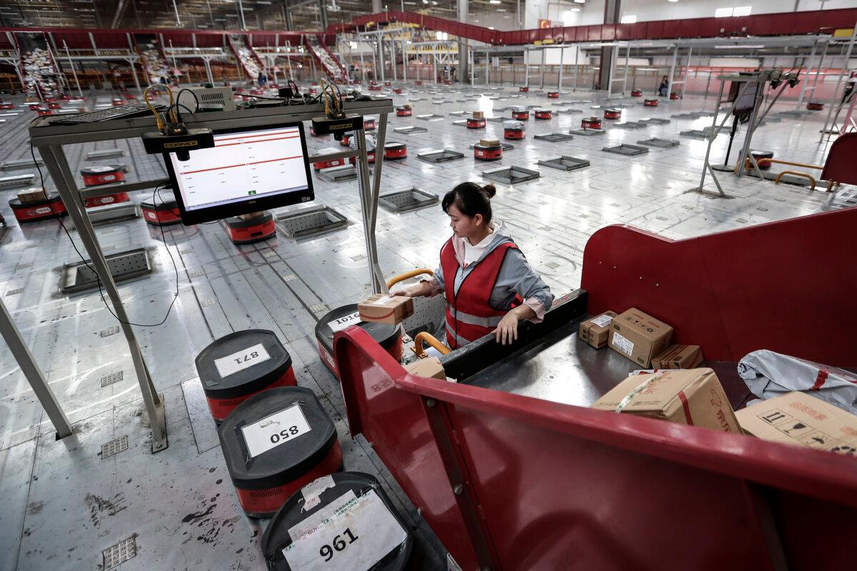 Employees will move parcels from conveyor belts to automatic robots in the warehouse of Jindong Group's logistics infrastructure in Wuhan, Hubei Province, China on November 5, 2019.