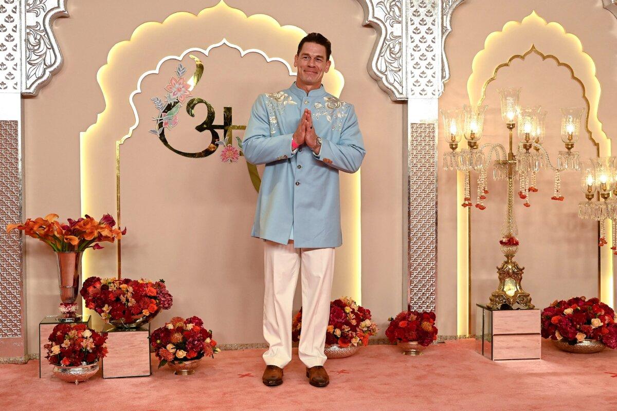Hollywood actor John Cena gestures as he arrives to attend the wedding ceremony of billionaire tycoon and chairman of Reliance Industries Mukesh Ambani's son Anant Ambani and Radhika Merchant in Mumbai, India, on July 12, 2024. (Sujit Jaiswal/AFP via Getty Images)