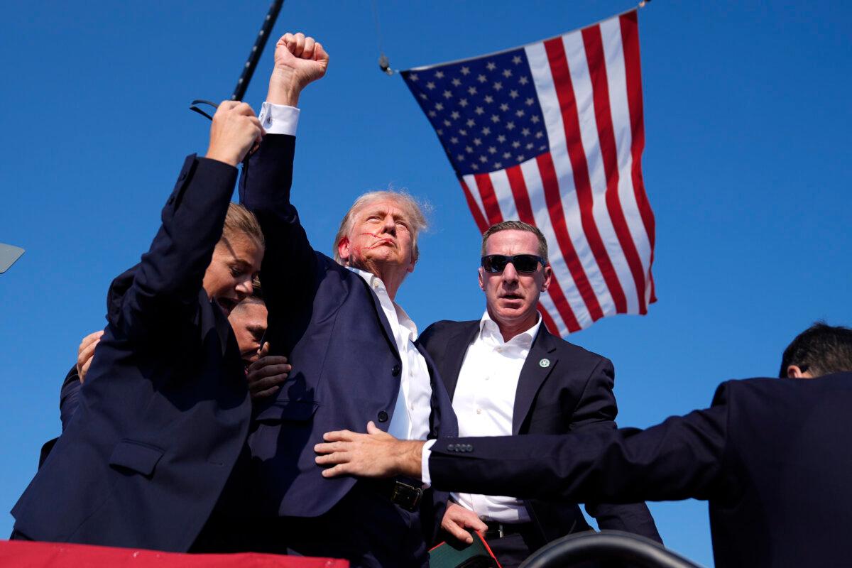 U.S. Secret Service agents rush to protect Former President Donald Trump after shots were fired during a campaign rally in Butler, Pa., on July 13, 2024. (Evan Vucci/AP Photo)