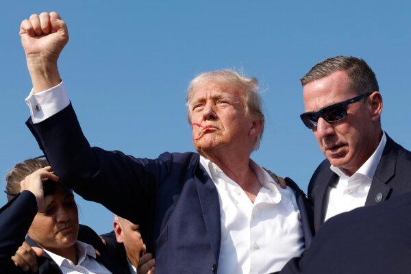 Former President Donald Trump pumps his fist as he is rushed offstage after an assassination attempt at a rally in Butler, Pennsylvania, on July 13, 2024. (Anna Moneymaker/Getty Images)