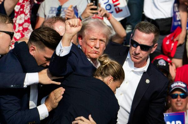 Republican candidate Donald Trump is seen with blood on his face surrounded by secret service agents at Butler Farm Show Inc. in Butler, Pennsylvania, on July 13, 2024. (Rebecca Droke/AFP via Getty Images)