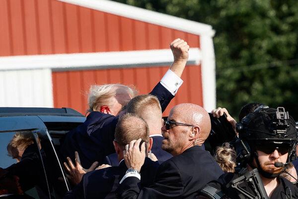 Republican presidential candidate former President Donald Trump pumps his fist as he is rushed into a car at a rally in Butler, Pa., on July 13, 2024. (Anna Moneymaker/Getty Images)