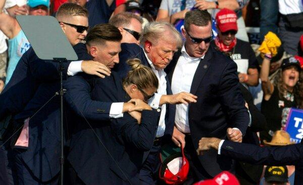 Former President Donald Trump with blood on his face as he is taken off the stage by Secret Service agents following an assassination attempt at a campaign event in Butler, Pa., on July 13, 2024. (Rebecca Droke/AFP via Getty Images)