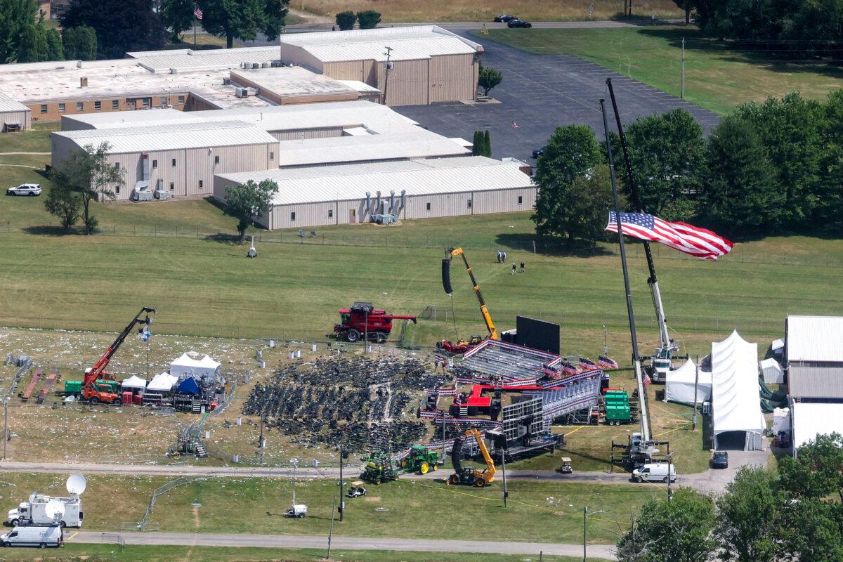 House Votes Unanimously to Form Task Force to Investigate Trump Assassination Attempt | USNN World News The stage where former President Donald Trump had been standing during an assassination attempt the day before, and the roof of a nearby building where a gunman was shot dead by law enforcement, in Butler, Pa., on July 14, 2024. (Brendan McDermid/Reuters)