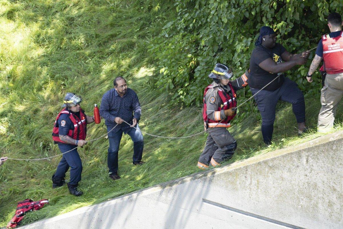 Drivers stranded due to flood waters blocking the Don Valley Parkway are rescued by fire crews following heavy rain in Toronto, on July 16 2024. (The Canadian Press/Arlyn McAdorey)
